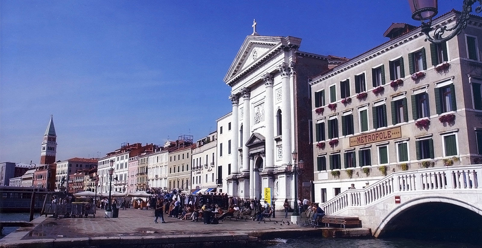 Waterfront building front with arched windows facing a broad quay