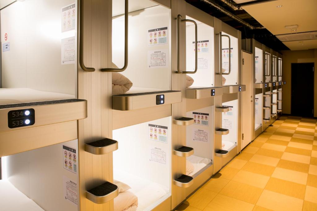 Two tiers of white capsule openings along a narrow lit corridor