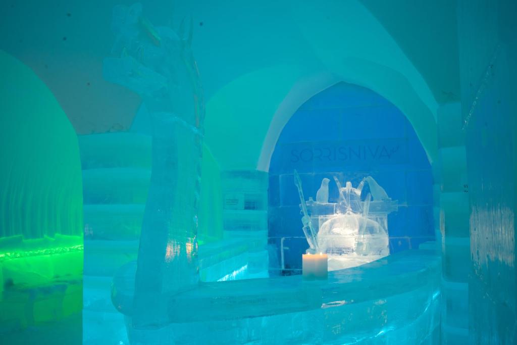 Carved ice wall behind a low bed platform in a hall of ice